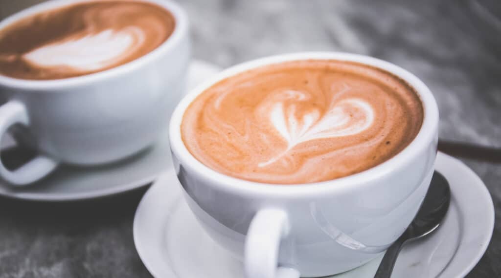 Two fresh cups of coffee side by side.